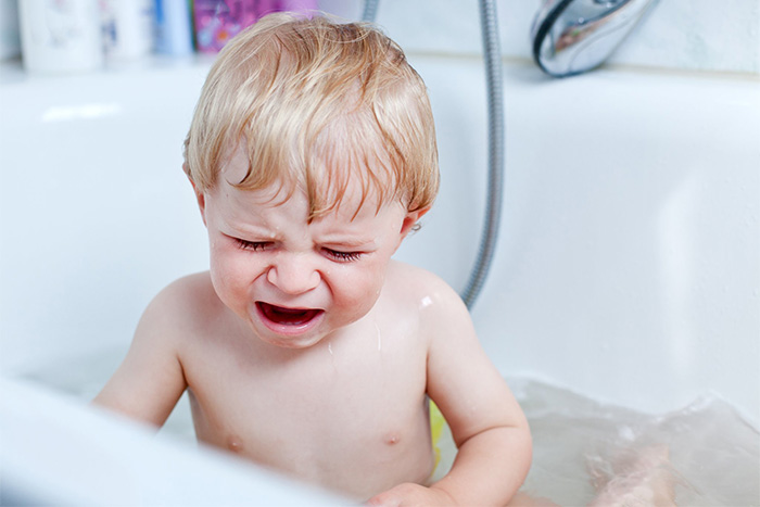 bébé a peur de se baigner dans le bain