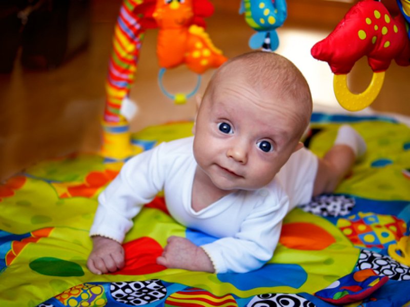 bébé sur le ventre près de jouets