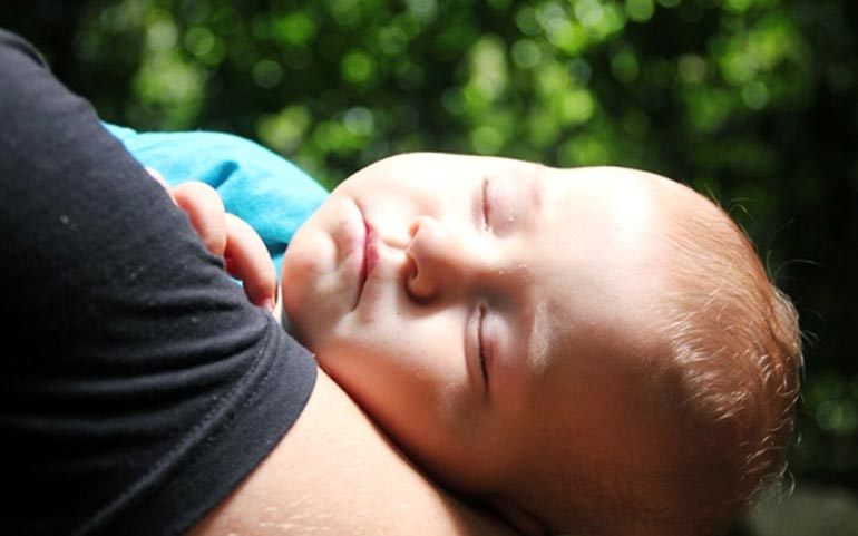 sommeil d'un enfant dans les bras de maman